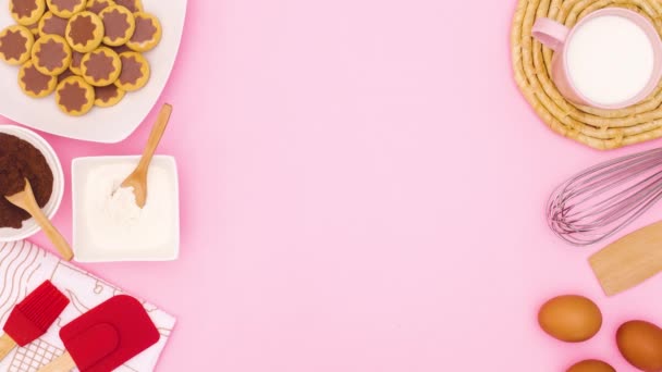 白盘子里的巧克力饼干和烘焙用的配料和用品出现在粉红的主题上 停止运动 — 图库视频影像