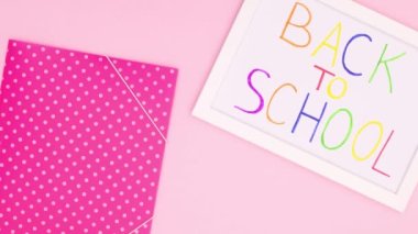 Okulun beyaz çerçevesi ve pembe temalı okul kağıtları. Hareketi durdur 