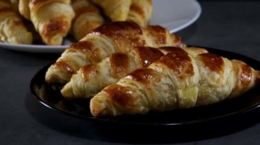 Koyu renk tabakta servis edilen lezzetli kruvasanlar.