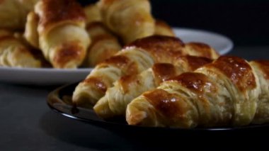 Koyu renk tabakta servis edilen lezzetli kruvasanlar.