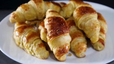 Koyu renk tabakta servis edilen lezzetli kruvasanlar.