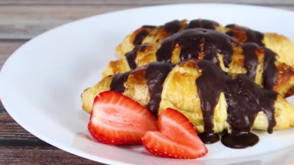 Köstliche Frische Süße Croissants Mit Geschnittenen Erdbeeren Auf Weißem Teller — Stockvideo