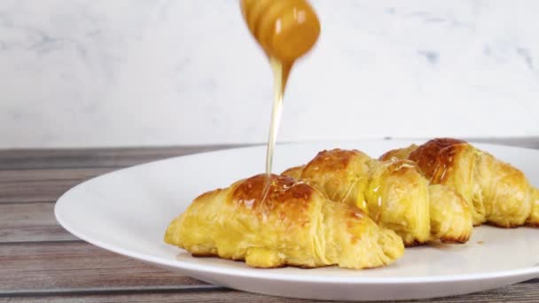 Versare Miele Deliziosi Croissant Freschi Piatto Bianco — Video Stock