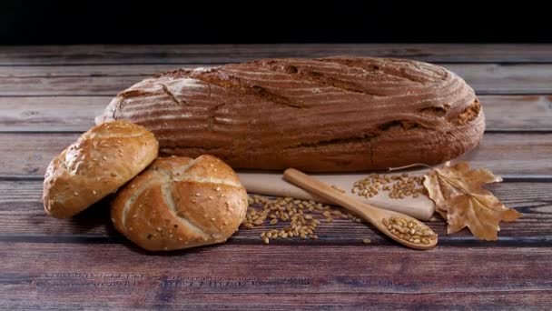 关闭美味的有机面包 百吉饼和黑麦面包与谷物在桌子上 — 图库视频影像