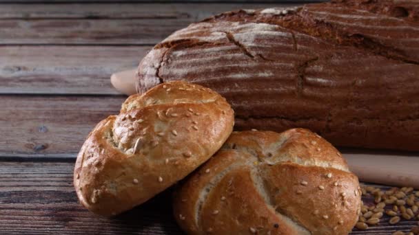 关闭美味的有机面包 百吉饼和黑麦面包与谷物在桌子上 — 图库视频影像