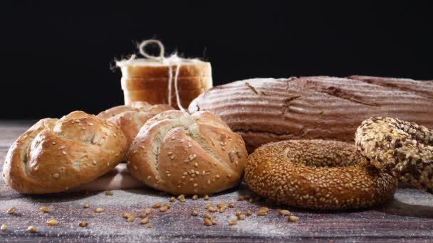 Bageriprodukter Ekologiskt Rågbröd Bullar Bagels Träbord Och Svart Tema — Stockvideo