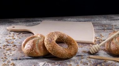 Baker masaya taze organik çavdar ekmeği, ekmek, simit ve un süslemesi koydu.