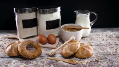 Taze fırın malzemeleri, süt, yumurta, un, tahıl, çörek ve eko dostu ve ahşap mutfak malzemeleri ile simit.