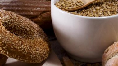 Beyaz kasedeki organik tahılları ahşap kaşık ve masanda pişirme malzemeleriyle kapatın.