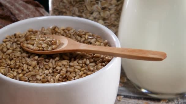 用木勺和放在桌上的烘焙食品 把有机谷物放在白碗里 — 图库视频影像