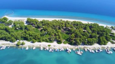 Kum plajları, yeşil ağaçları ve kenetlenme için rıhtımı olan inanılmaz mavi göl adası. Hava görünümü