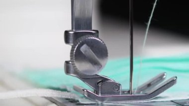 Dikiş makinesi ve iğne aşağı yukarı hareket ederken tıbbi maske takma işleminin makro kapanışı