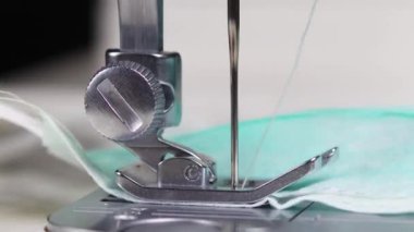 Dikiş makinesi ve iğne aşağı yukarı hareket ederken tıbbi maske takma işleminin makro kapanışı