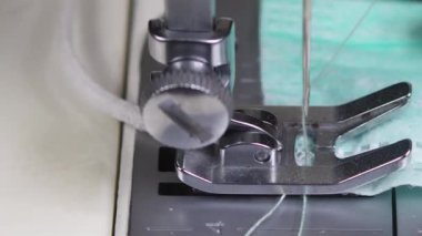 Dikiş makinesi ve iğne aşağı yukarı hareket ederken tıbbi maske takma işleminin makro kapanışı