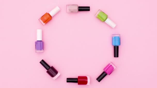 Bunte Flaschen Nagellack Bewegen Sich Kreis Auf Rosa Thema Stop — Stockvideo