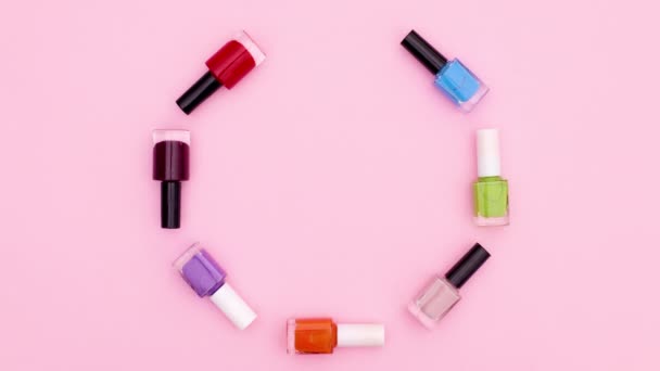 Garrafas Coloridas Esmaltes Movem Círculo Sobre Tema Rosa Parar Movimento — Vídeo de Stock