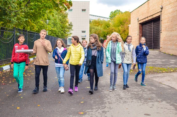 ロシア、モスクワ、2018 年 9 月 23 日若い男の子と話していると、道を歩きながら女の子のグループ. — ストック写真