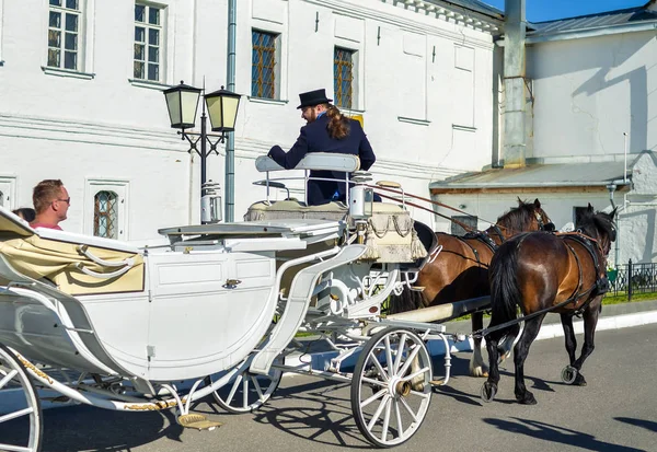Kolomna, Rusya-11 Ağustos 2018. Siyah şapka ve turist taşıyan kahverengi atlar ile faytoncular zarif beyaz taşıma