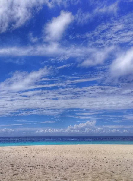 sand sky ocean and clouds midday.  Maldives islands