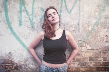 bir grafiti kalp önünde gülümseyen genç bir kadın portresi