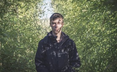 Genç bir adam portresi gölgeler bir bambu ormanın yüzü