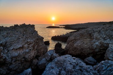 Akdeniz manzara, taşlık bir kıyı üzerinde gün batımı