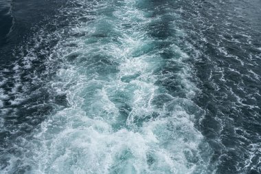 Okyanusun bir feribotla arkasında su yüzeyinde iz