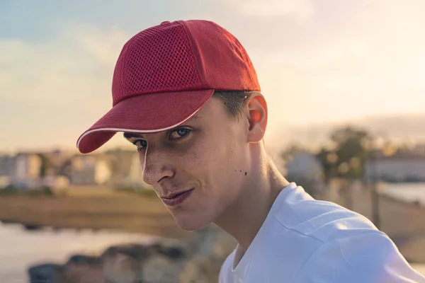 Portret van een glimlachende jonge man met rode baseball cap — Stockfoto