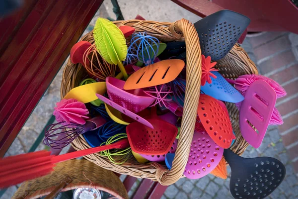 Many colorful plastic kitchen tools in a basket — Stock Photo, Image
