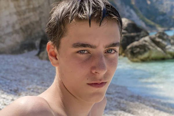 Портрет молодого человека, сидящего на пляже — стоковое фото