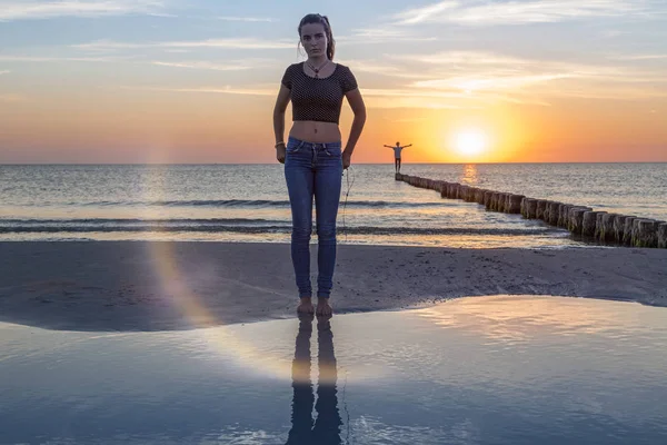 Tramonto sul mare baltico, ritratto di una giovane donna in piedi sulla spiaggia — Foto Stock