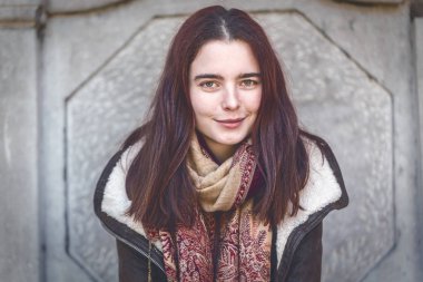 deri ceketli gülümseyen genç bir kadının portresi