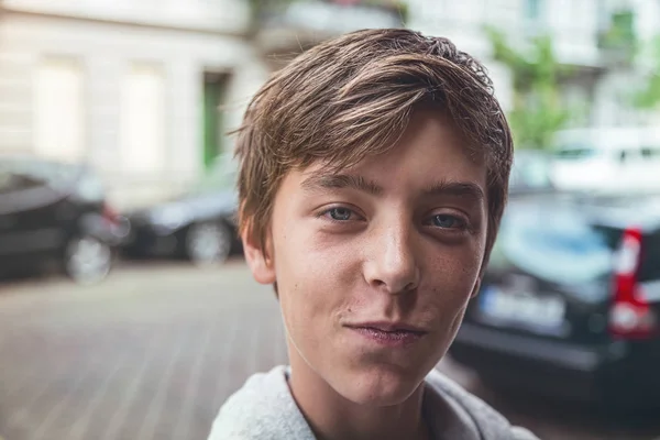 Retrato de um jovem sorridente com carros embaçados no fundo — Fotografia de Stock