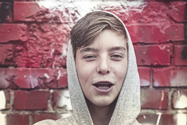 Porträtt av en lycklig ung man med tandstag och hoodie — Stockfoto