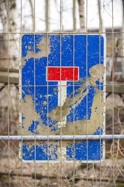 Señal de tráfico sucio callejón sin salida alemán, detrás de una valla de metal —  Fotos de Stock