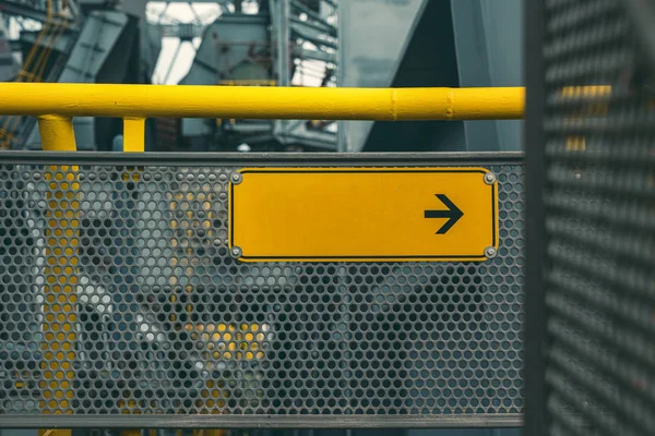 Instalación industrial, señal de dirección vacía amarilla con flecha negra —  Fotos de Stock
