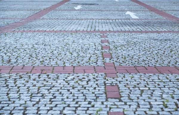 Kırmızı çizgiler ve beyaz oklar ile arnavut kaldırımı taş sokak — Stok fotoğraf