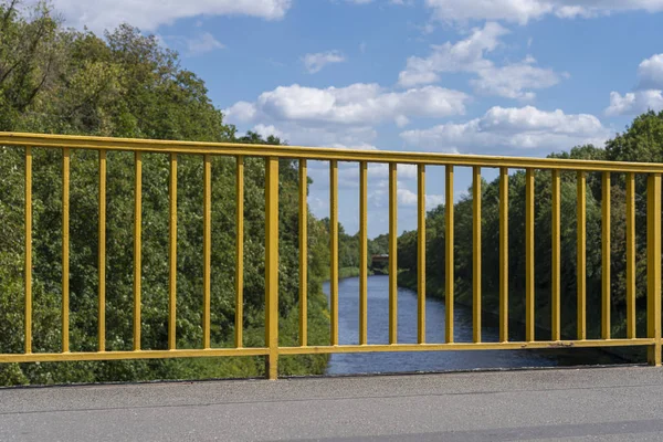 Garde-corps jaune sur un pont d'une rivière — Photo