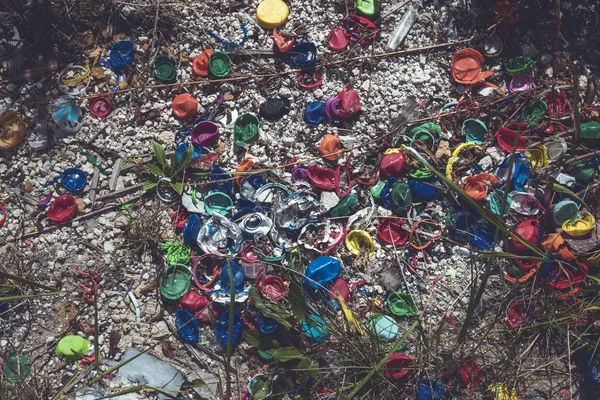 Diferentes tampas de rosca de plástico colorido deitado no chão — Fotografia de Stock