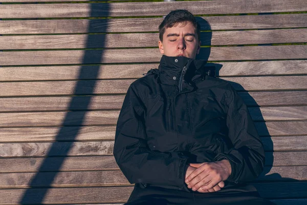 Young Man Sitting Bench Sun His Eyes Closed — Stock Photo, Image