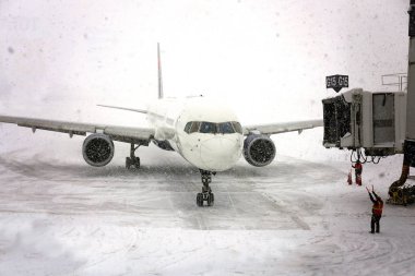 Bir ticari jet uçak bir Havalimanı kar fırtınası gibi bir kar fırtınası'nda kapıya çekerek.