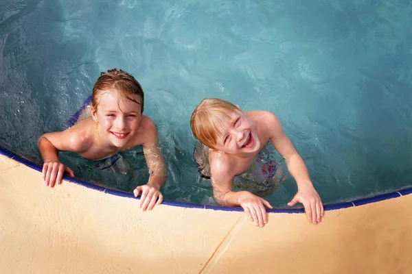两个快乐的孩子是兄弟 夏天在家里的后院游泳池里游泳时 他们面带微笑 — 图库照片