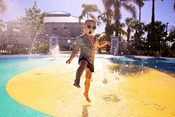 Klein kind spelen in Water bij Splash Park op zomerse dag — Stockfoto