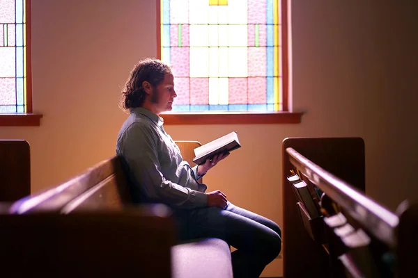 Man zit alleen in Dark lege kerk Pew door Bright gekleurd Gla — Stockfoto