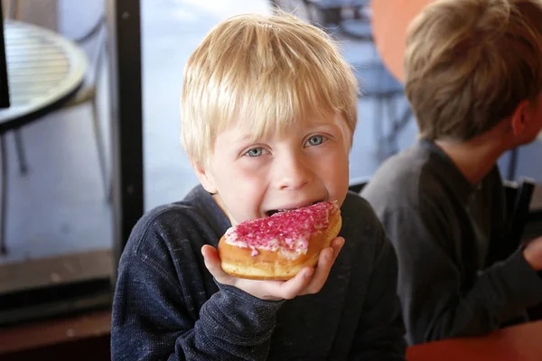 Kisfiú gyermek evés Forsted Donut a pékségben az ő családja — Stock Fotó