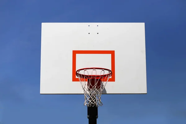 Открытый баскетбольный обруч и носилки изолированные против голубого неба — стоковое фото