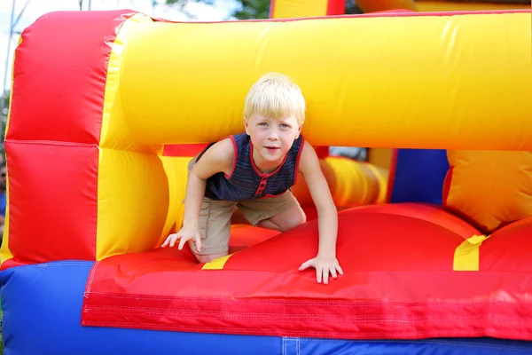 Cute Little Kid gra na nadmuchiwane Bounce House przeszkody Cour — Zdjęcie stockowe