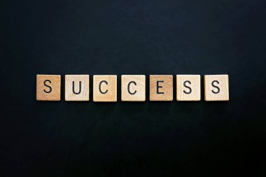 Kelime başarısı siyah deri bir arka planda tahta bloklarda hecelenir..