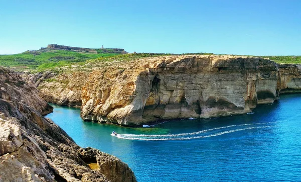 Gozo Adası manzaralı. Kayalıklarla, deniz, tekne ve deniz feneri. Malta ülke