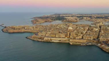 Valletta şehir ve kilisenin havadan görünümü 4k. Günbatımı gökyüzü. Malta Adası